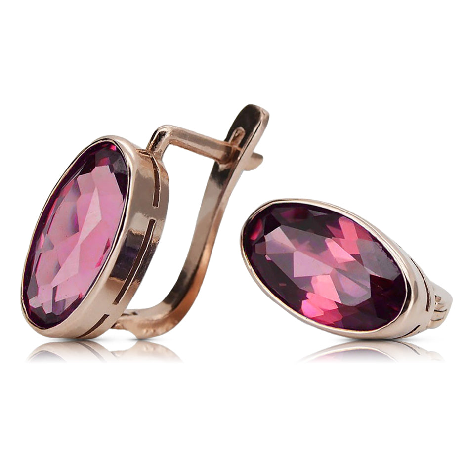 Oval ruby earrings in 14K rose gold, pair on a square white background